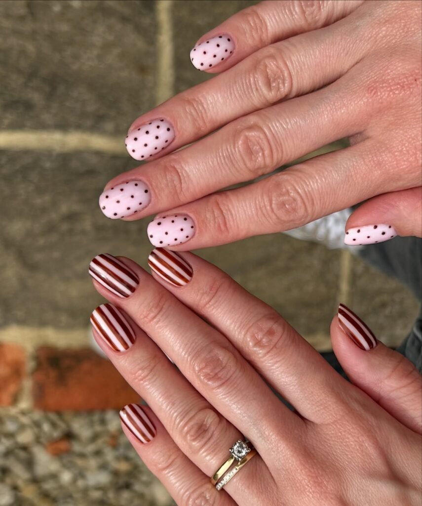 Pink polka dot and striped gel nail ideas for short nails in brown and pink with outdoor setting.