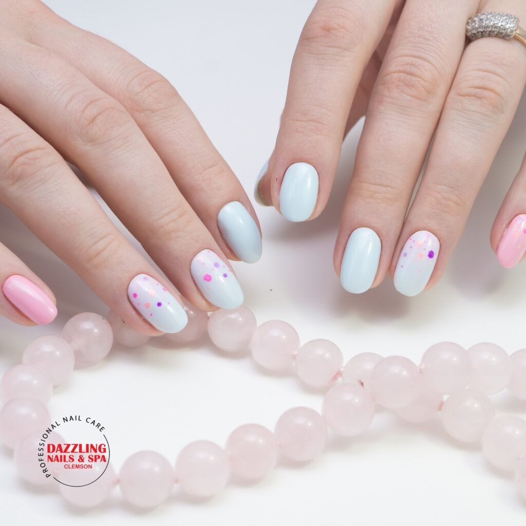 Pastel confetti dot gel nail ideas for short nails in blue and pink gradients with bead jewelry.