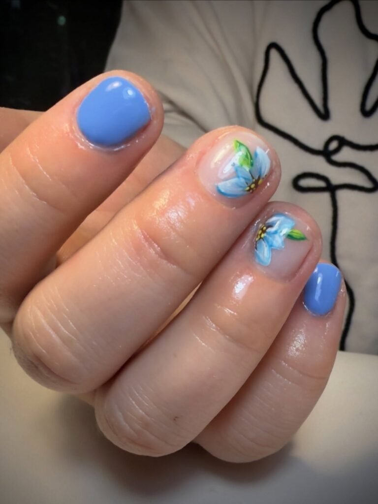 Very short nails ideas featuring light blue polish with a subtle flower accent.