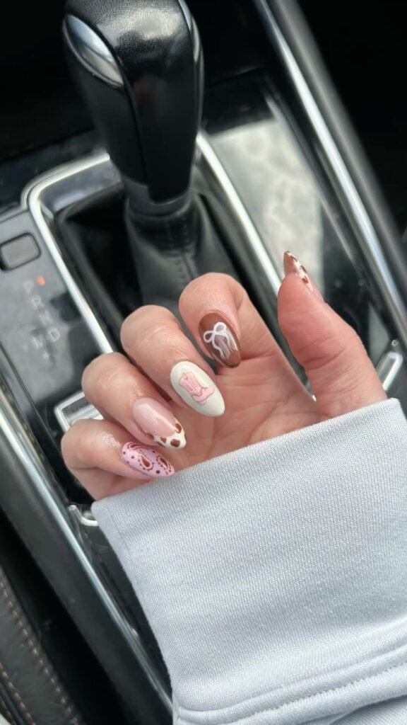 Stylish country concert nails ideas featuring cowboy motifs like cow prints, boots, and bows ideal for a country music show.