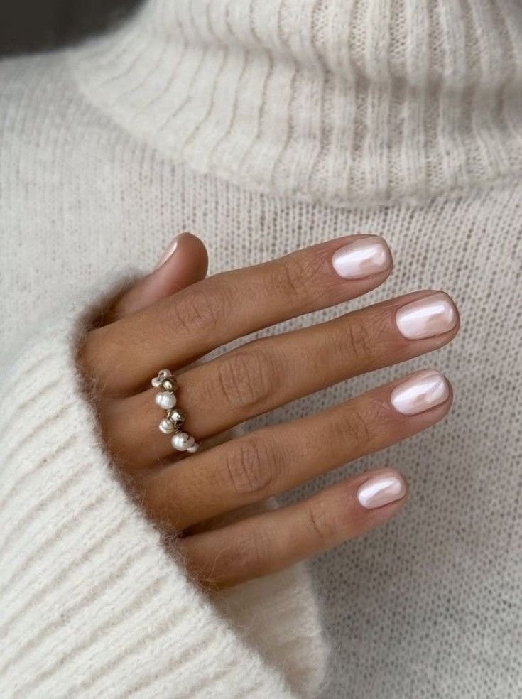 Elegant nude short nails ideas featuring a pearly pink polish and pearl cluster ring for a sophisticated look.