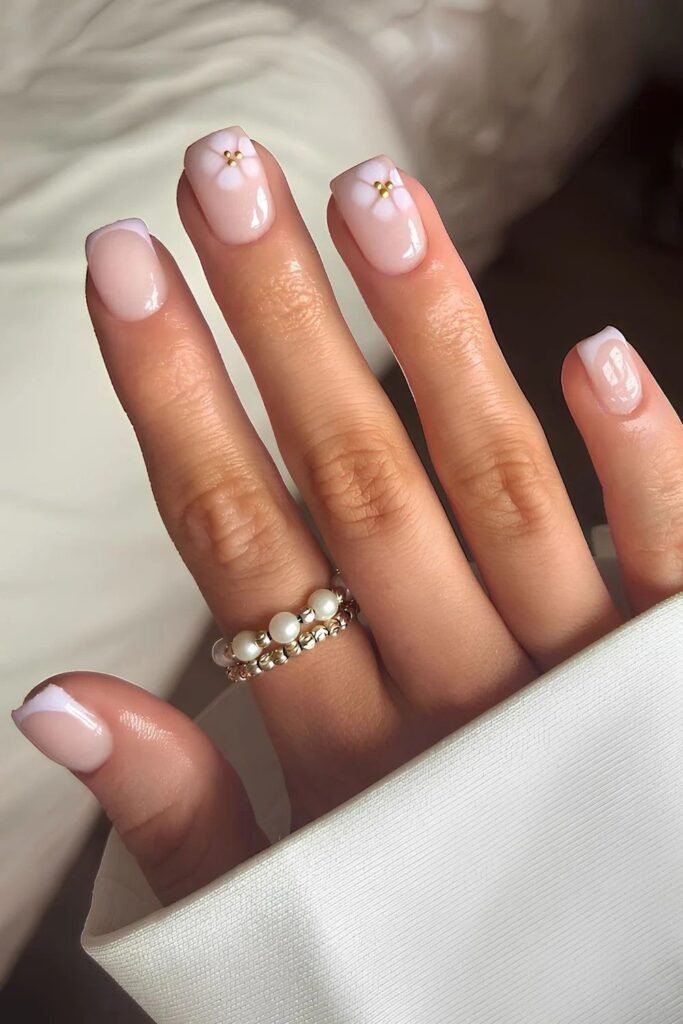 Elegant short spring nails ideas featuring French tips and gold star details.