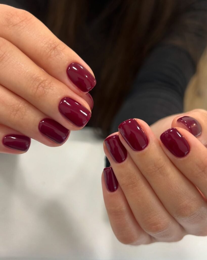Bold short round nails ideas featuring deep maroon polish for a sophisticated and timeless appearance.