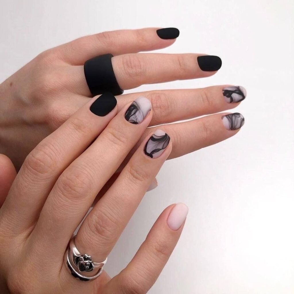Artistic black short nails ideas incorporating marble swirls in monochrome tones for a sophisticated and varied look.