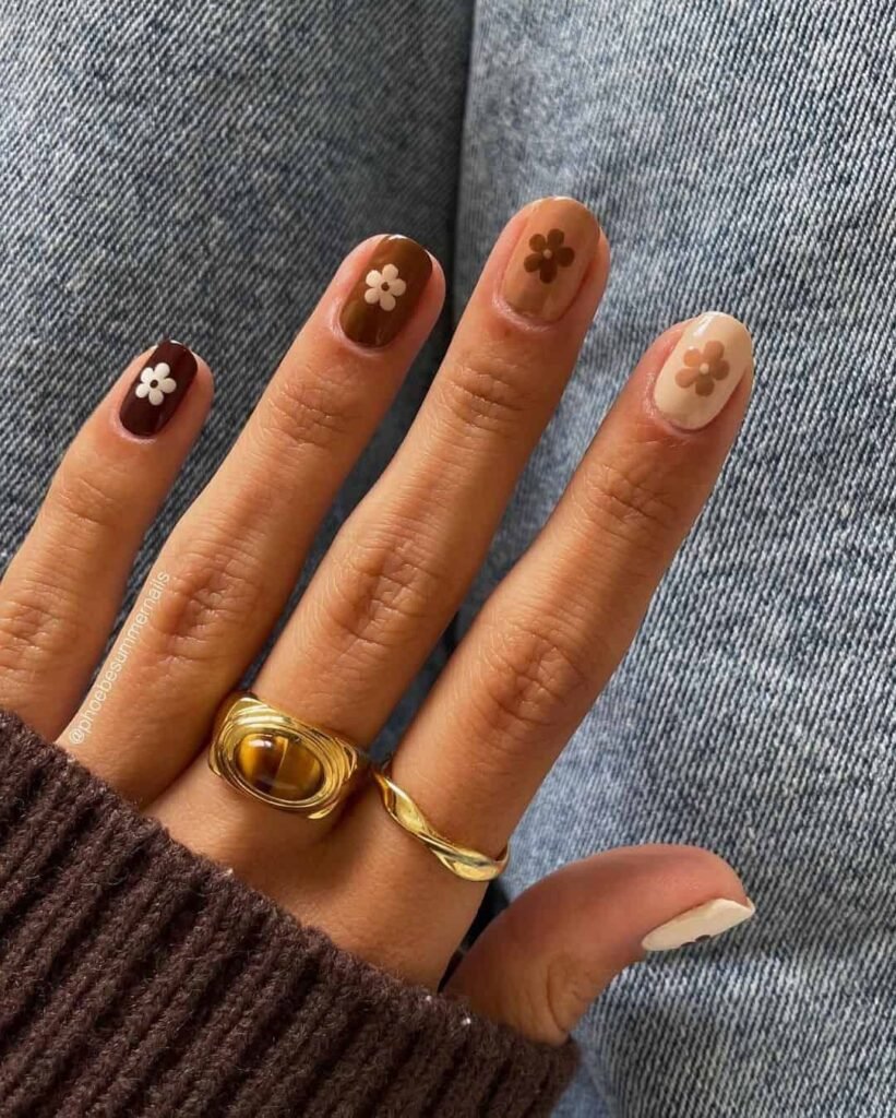 Fun short brown nails ideas incorporating floral motifs in earthy tones for a boho-inspired manicure.
