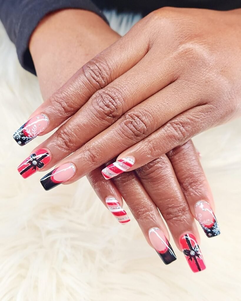 Vibrant concert nails ideas inspired by holiday themes, featuring snowflakes, candy canes, bows, and glitter in festive red and black tones on long manicured nails.