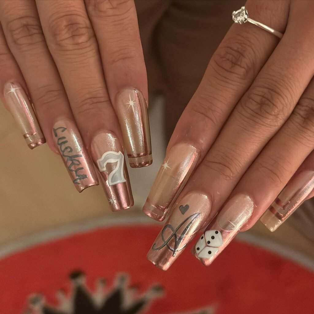 Glamorous vegas nails ideas in rose gold tones featuring lucky 7, dice, and ace symbols for a fortunate gambling theme.