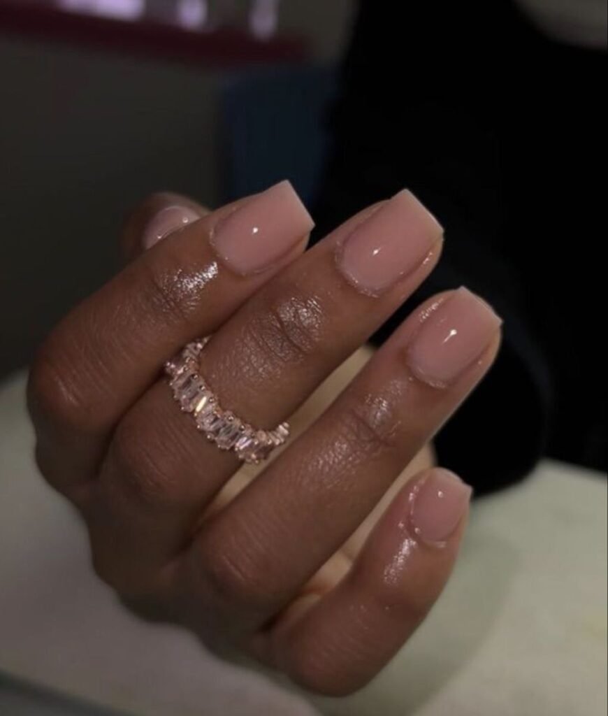 Beautiful nude short nails ideas showcasing a glossy pink polish paired with an elegant crystal ring for everyday glamour.