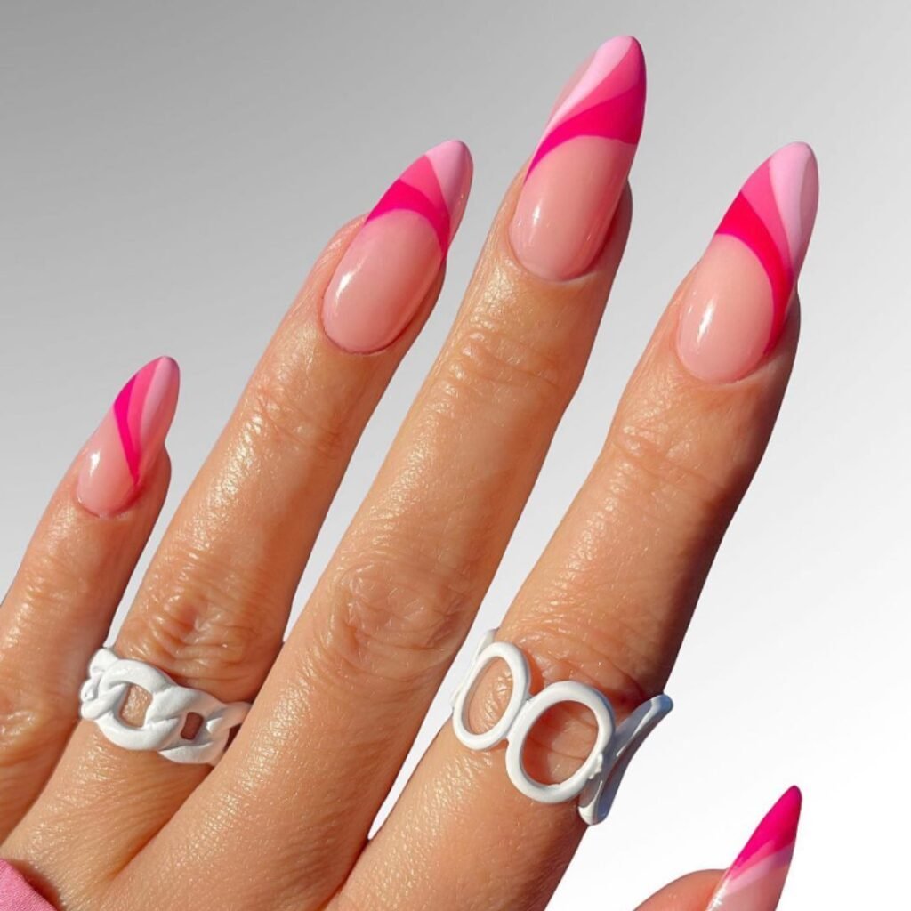 Stylish barbie nails featuring gradient pink stripes and curves on long almond shapes.