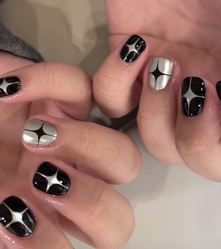 Various angles of hands with black and silver nails adorned with star designs, highlighting creative short black nails ideas for a starry, cosmic appeal.