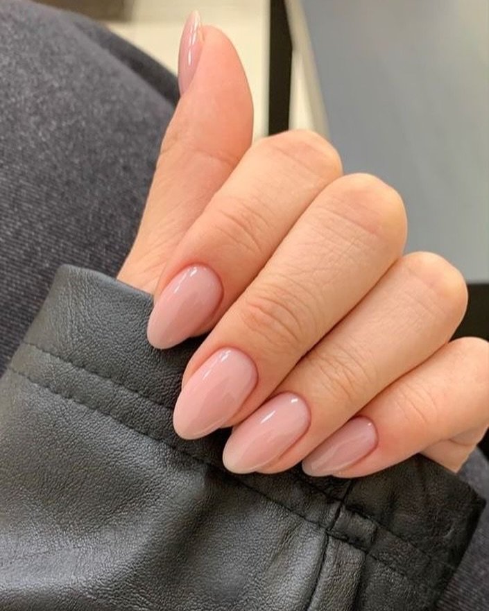 Explore elegant short almond nails ideas with a glossy light nude pink polish, perfect for a minimalist and sophisticated everyday manicure that pairs beautifully with any outfit.