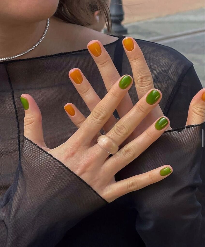 Short green nails ideas paired with orange for a bold, seasonal gradient effect.