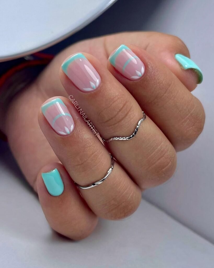 Close-up of simple short nail ideas featuring mint green French tips on a pink base, complete with a delicate white accent.