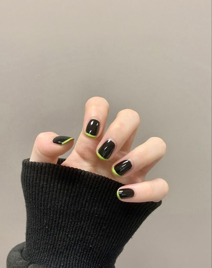 Creative black short nails ideas with glossy black polish and neon green tip accents for an edgy, minimalist manicure style.