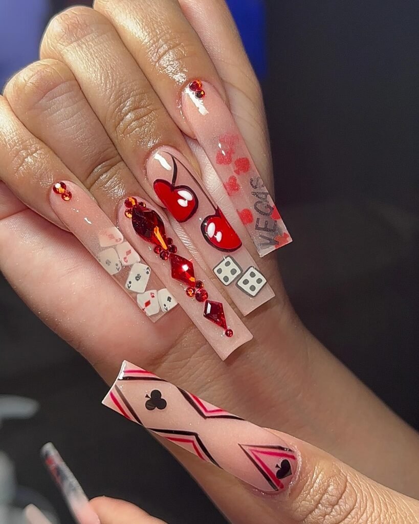 Extravagant Vegas nails ideas for long coffin shapes with cherries, dice, cards, and "VEGAS" motifs in pink and red.