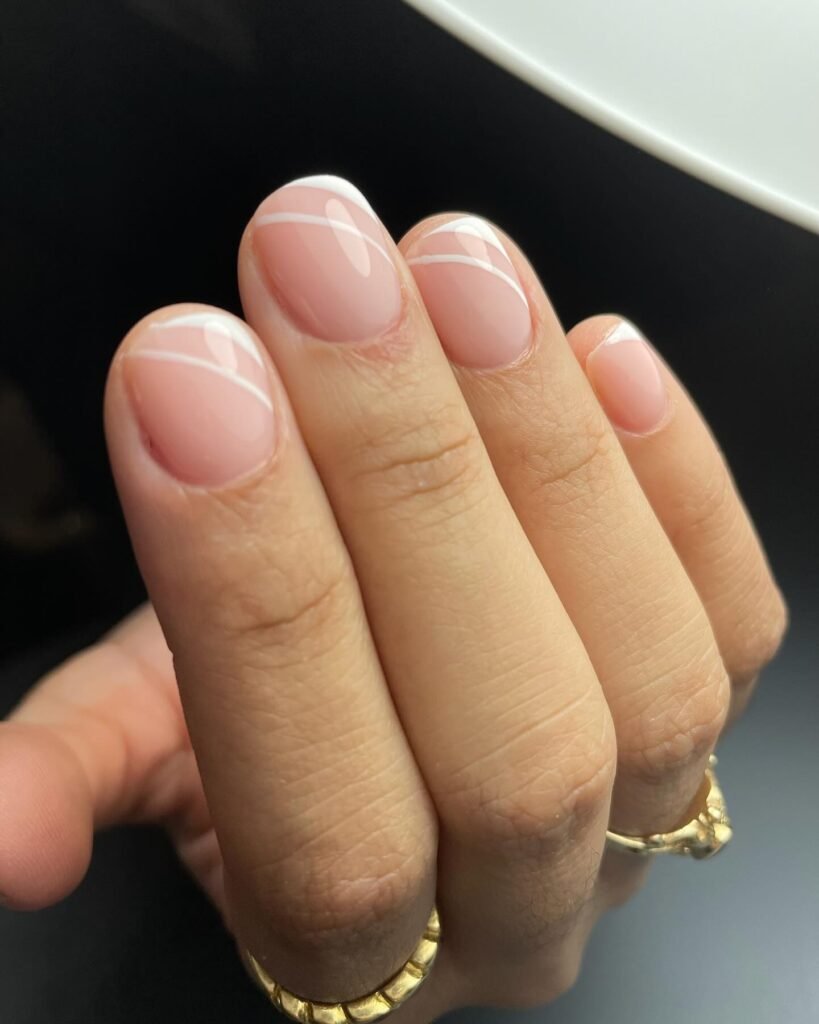 Very short nails ideas in nude pink with white diagonal lines.
