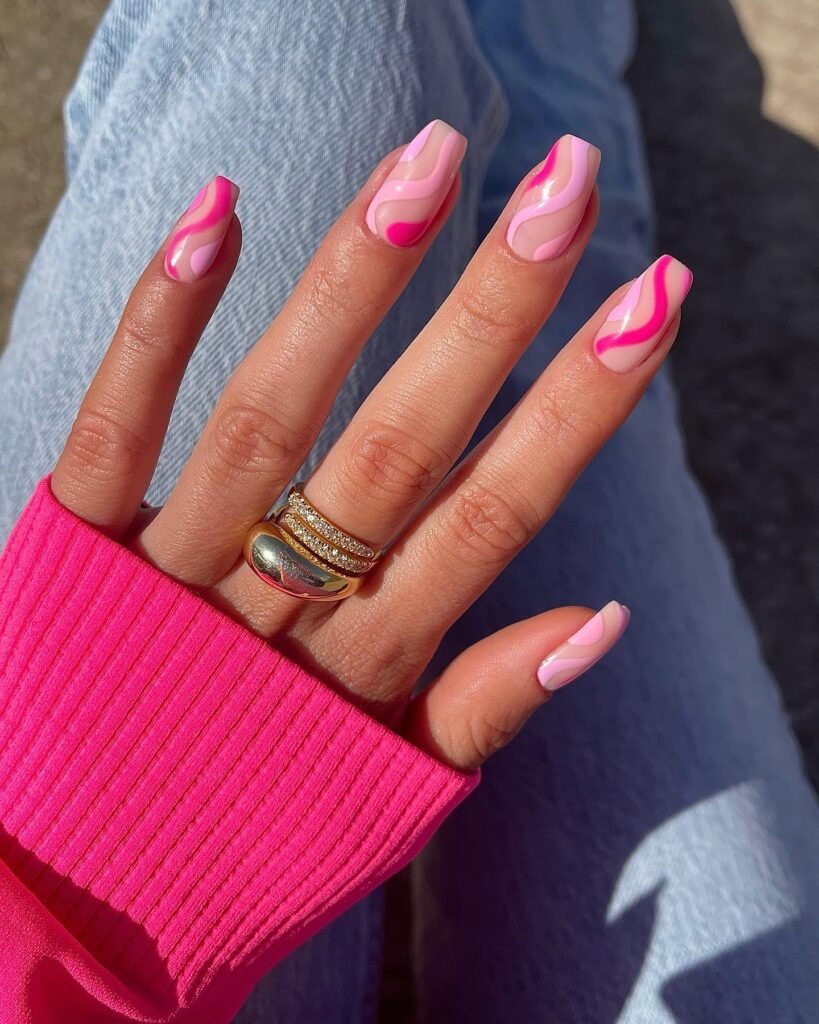 Trendy barbie nails showcasing pink and nude swirly waves for a retro-inspired aesthetic.