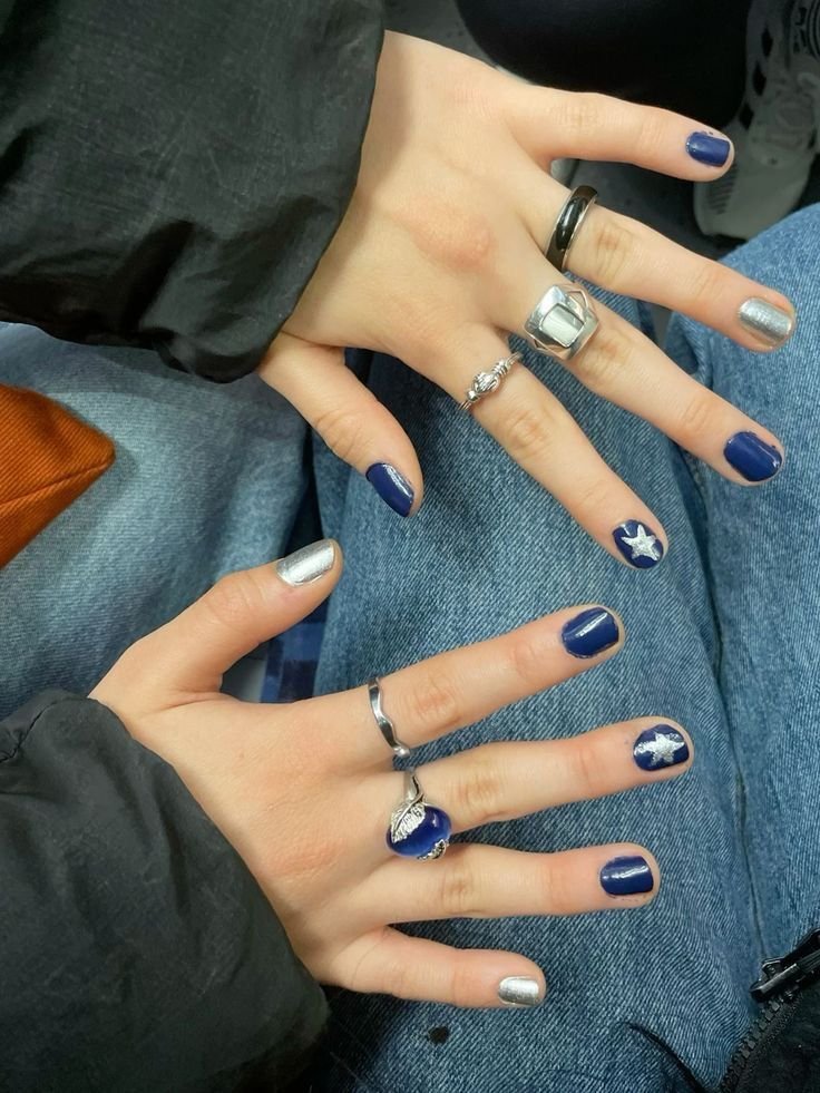 Starry blue nails ideas short blending navy and silver with celestial motifs for an edgy touch.