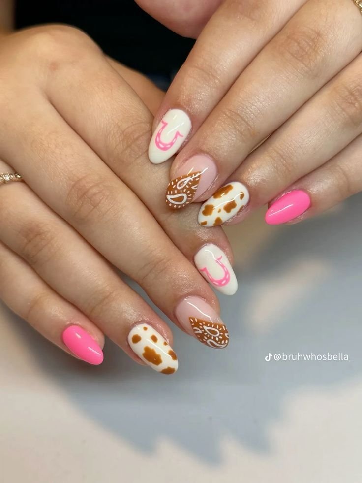 Cute concert nails ideas inspired by western themes with cow prints, horseshoes, and paisley in pink and brown shades.