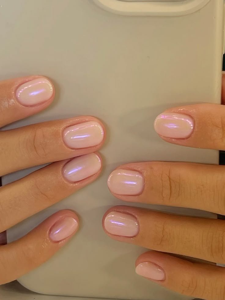 Stunning nude short nails ideas featuring an iridescent pink polish for a subtle, shimmering effect on rounded tips.