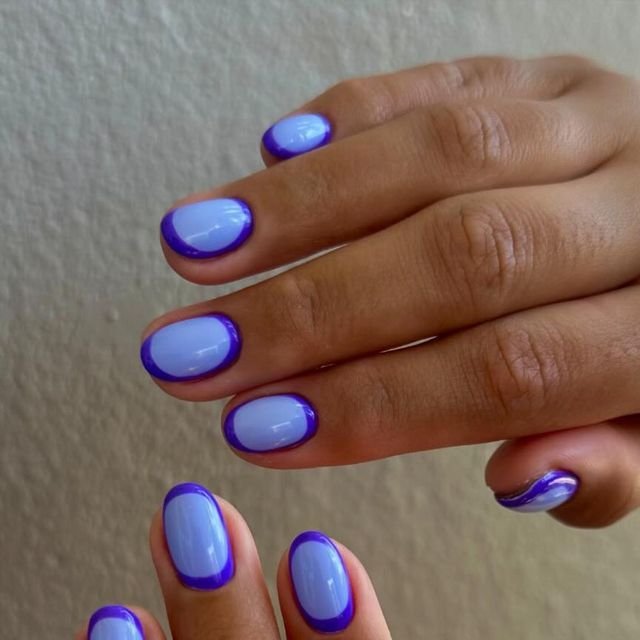 Vibrant pastel blue short round nails ideas accented with purple borders for a playful edge.