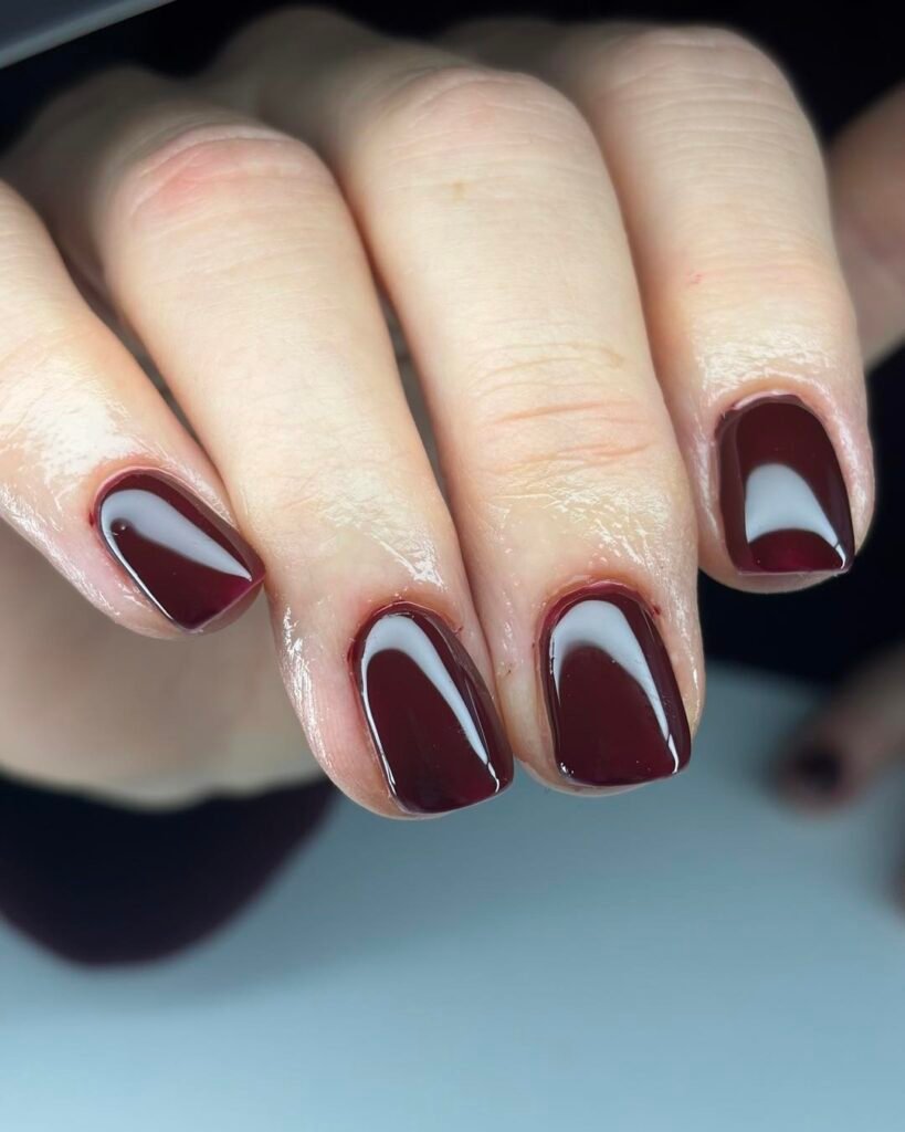 Close-up of glossy deep burgundy polish on short square nails ideas perfect for a sophisticated everyday look.