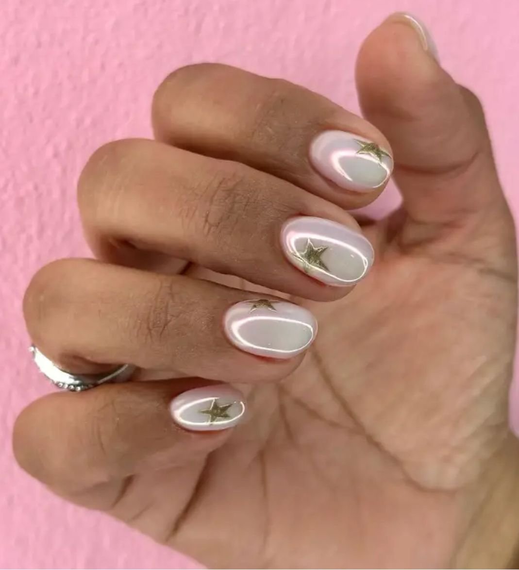 Playful white short nails ideas with gold star accents on a pearlescent base.