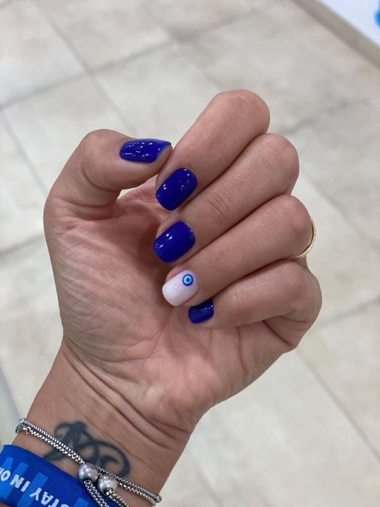 Mystical blue nails ideas short with an evil eye accent on one nail for a protective, chic manicure.
