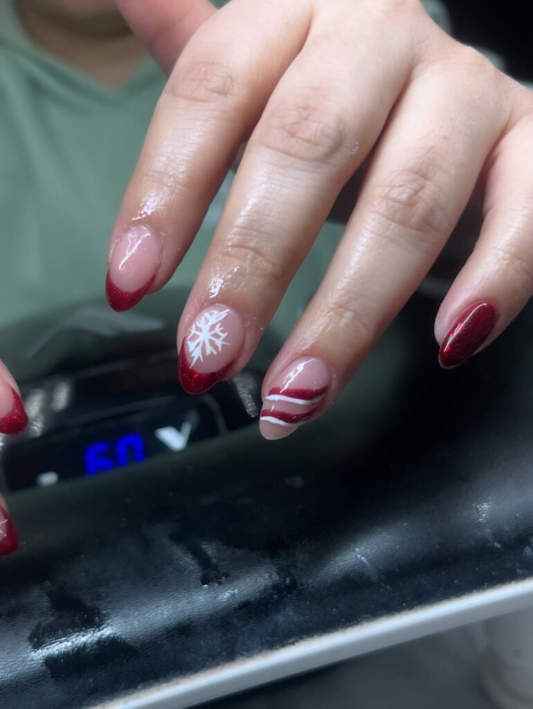 Inspiring red short nails ideas with holiday-themed snowflakes and stripes for a festive vibe.