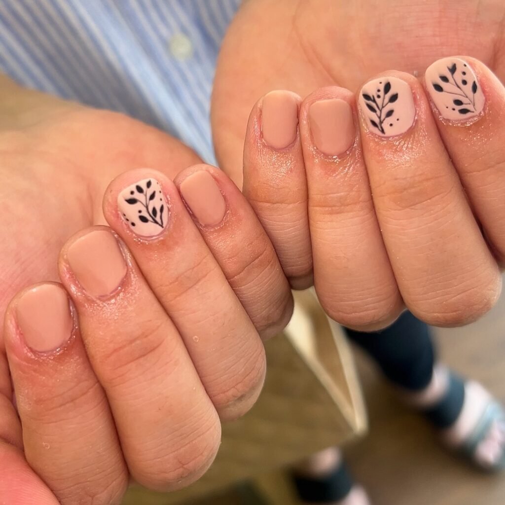 Simple very short nails ideas with subtle black botanical drawings on a soft nude base for everyday wear.