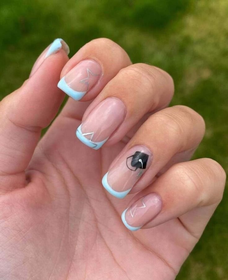 Subtle graduation nails ideas featuring light blue French tips, silver geometric accents, and a black grad cap for an understated elegance.