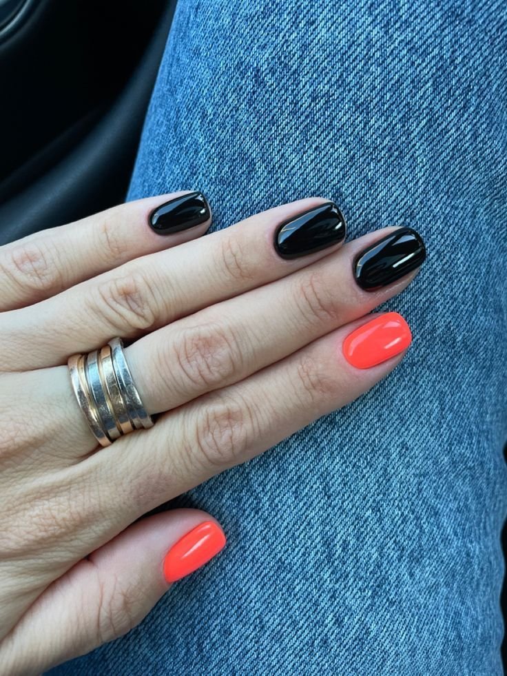 Vibrant black short nails ideas with a pop of orange accent on glossy polish, perfect for adding a fun twist to classic dark manicures.