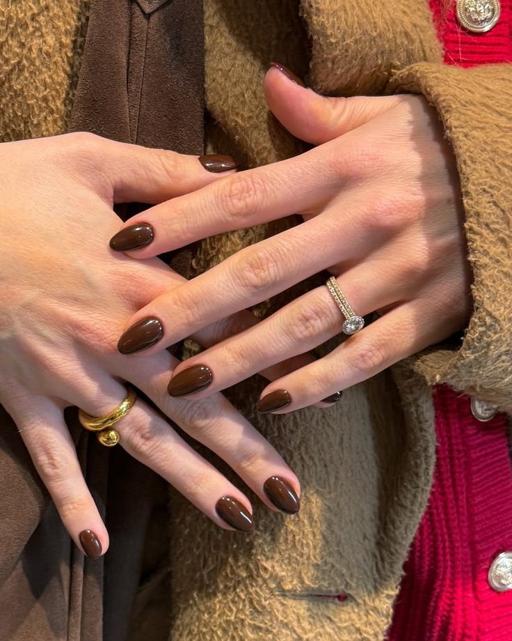 Timeless short brown nails ideas in solid chocolate shades, enhanced with elegant rings for a sophisticated look.