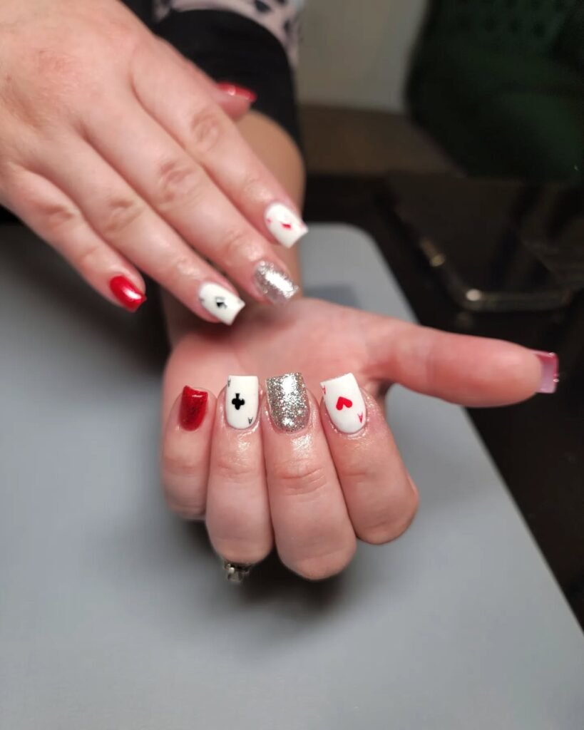 Inspiring Vegas nails ideas featuring classic playing card suits in red, black, white, and silver glitter.