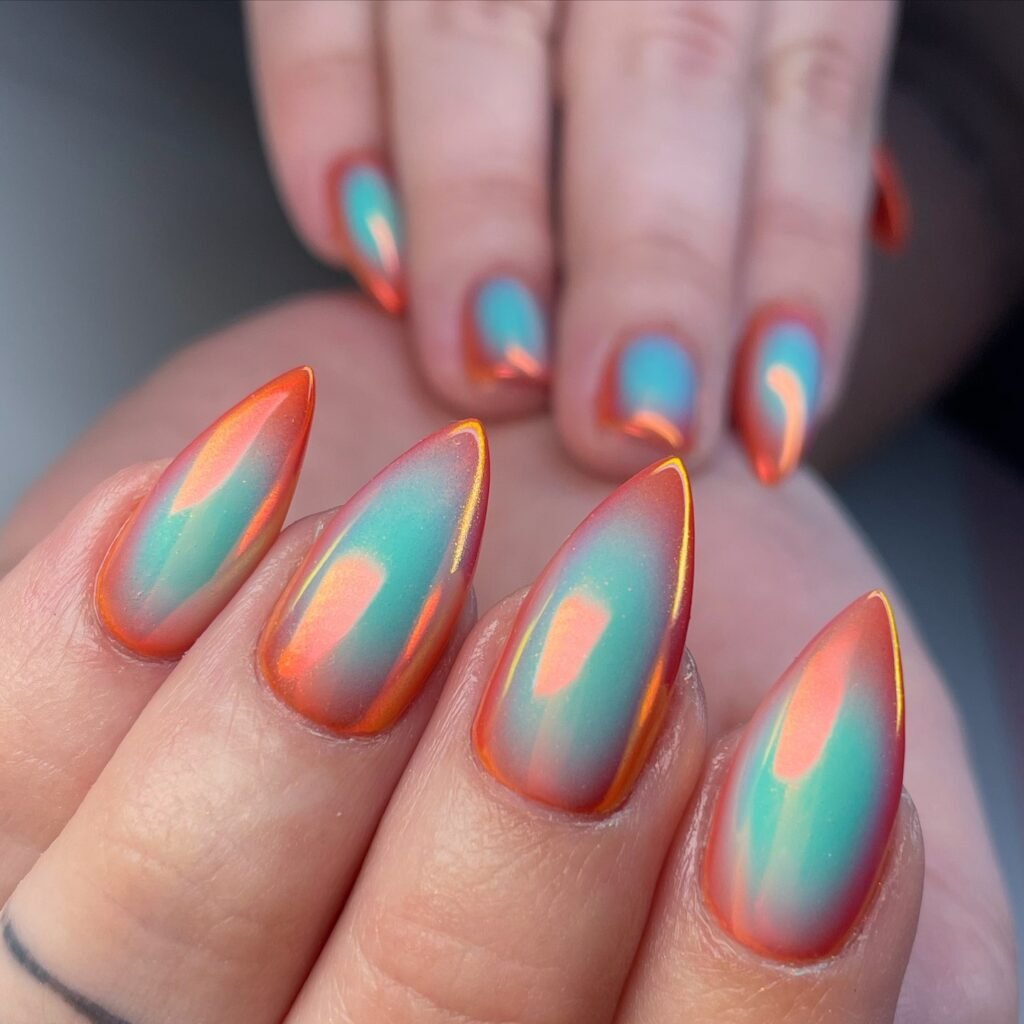 Hypnotic april nails ideas showcasing iridescent teal and orange chrome nail art.