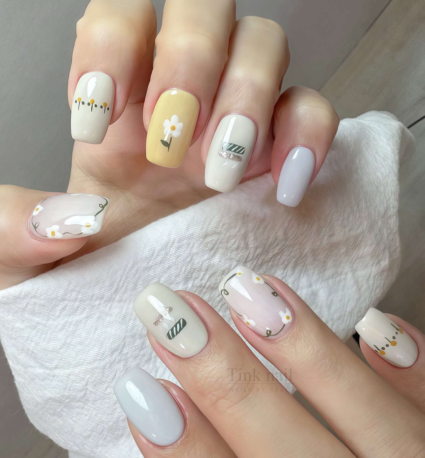 Delicate april nails ideas with pastel daisy flowers and soft spring nail art.