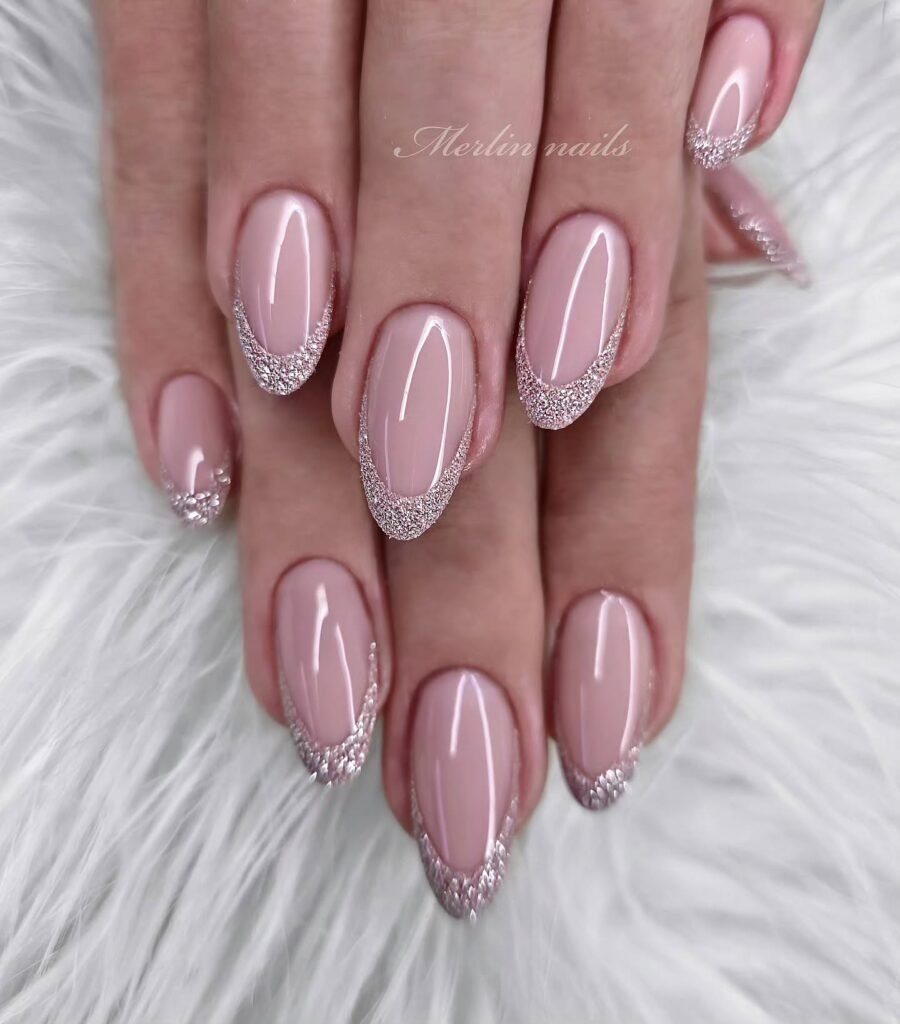 Elegant april nails ideas featuring soft blush pink nails with sparkling silver glitter tips.