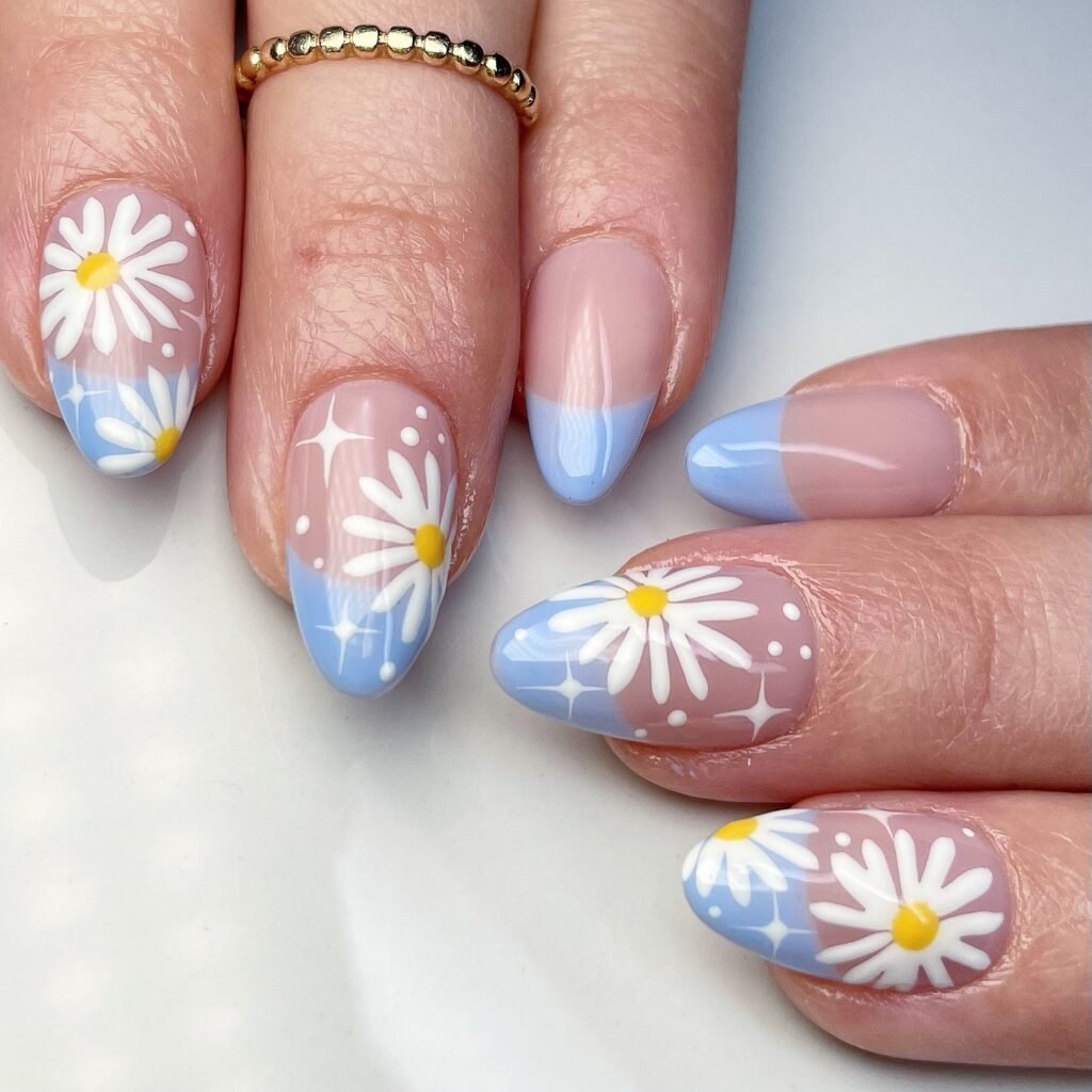 Cute and fresh april nails ideas featuring daisy flowers on a soft pink and blue ombre.