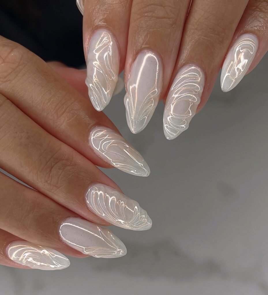 Dreamy engagement nails ideas featuring pearlescent swirls on long almond nails.