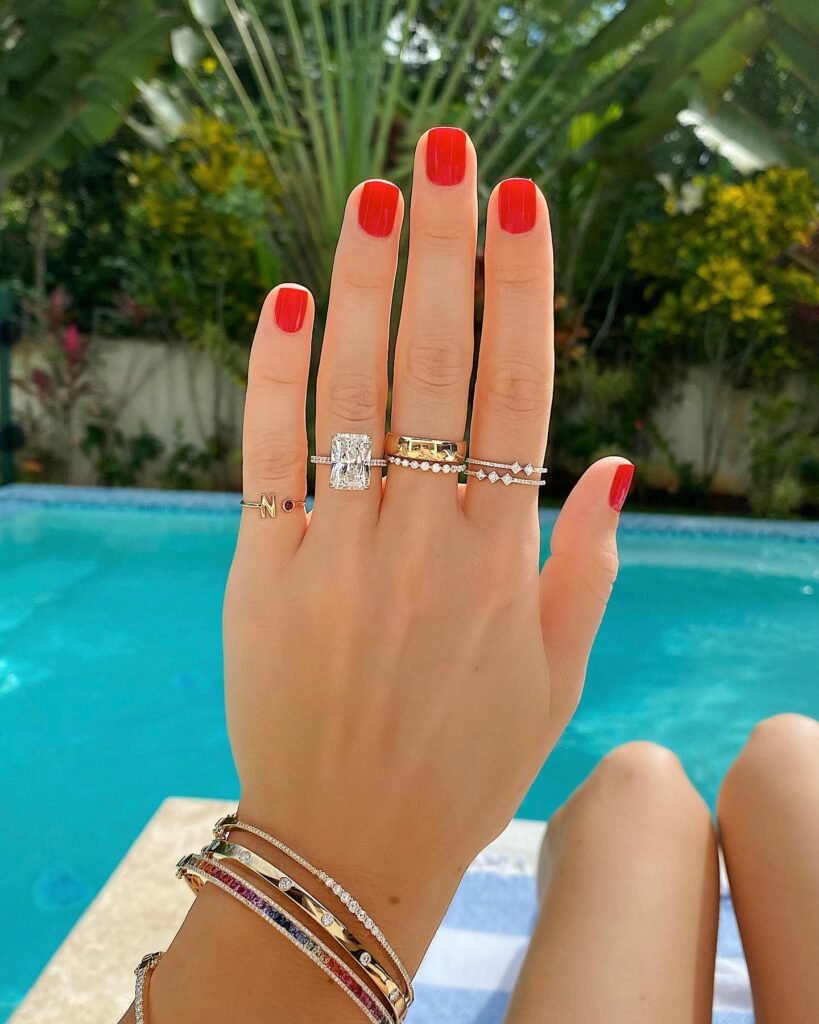 Bold engagement nails ideas in vibrant red with a stunning diamond engagement ring.