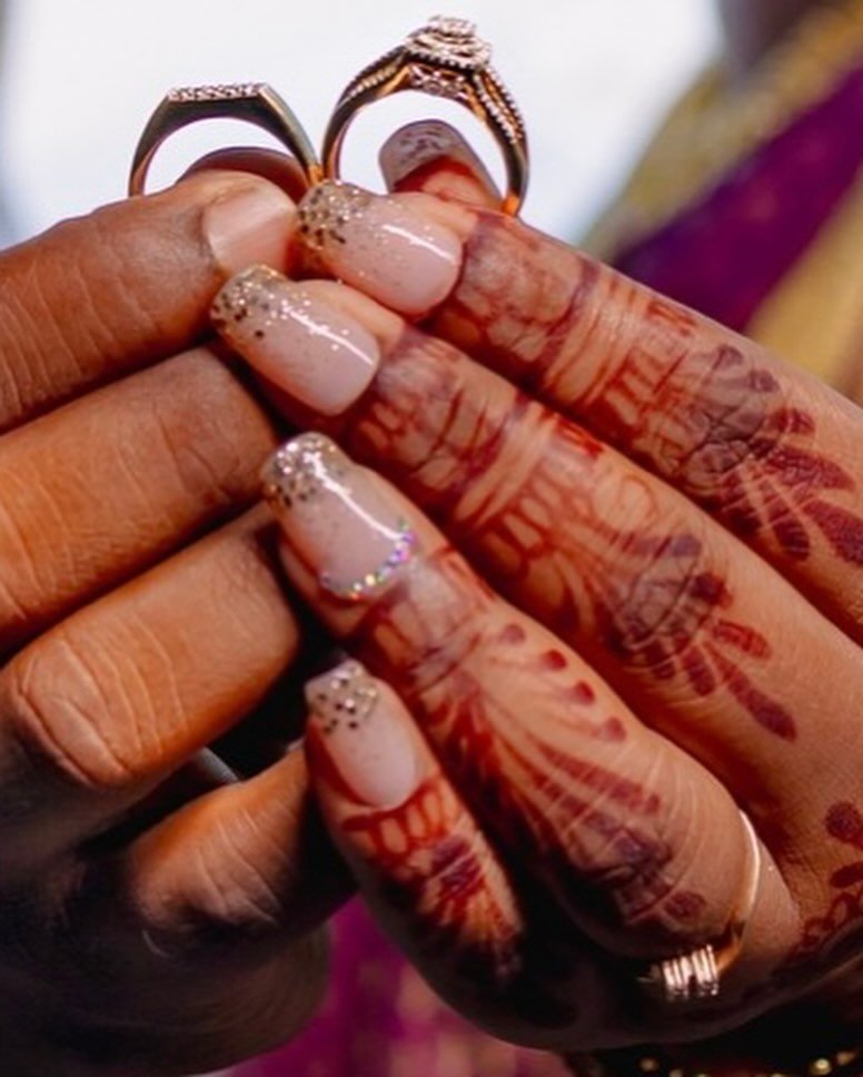 Gorgeous engagement nails ideas indian featuring soft nude glitter nails with rhinestones, beautifully complemented by traditional henna and engagement rings.