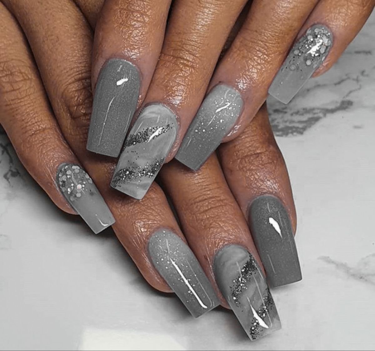 Sophisticated grey nails ideas with ombre gradients, marble effects, and glitter accents for a trendy, textured appearance.