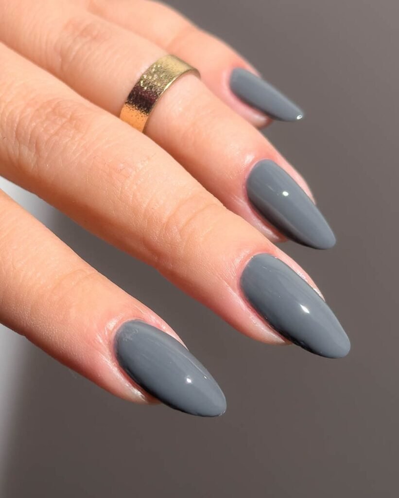 Elegant grey nails ideas featuring solid slate grey polish on almond-shaped nails for a minimalist look.