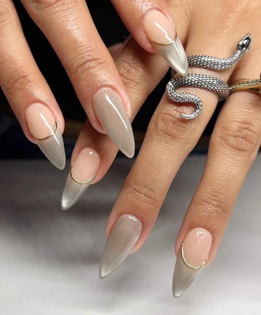 Stylish grey nails ideas with ombre gradients from nude to grey and gold cuticle accents on stiletto tips.