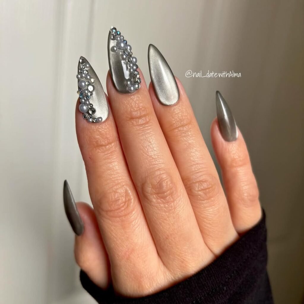 Glamorous grey nails ideas with stiletto shapes and pearl crystal embellishments for a bold, elegant manicure.