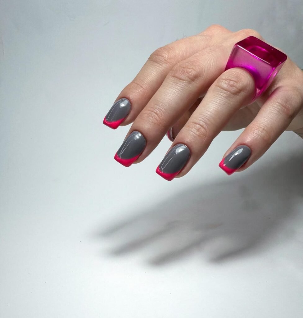 Striking grey nails ideas featuring hot pink French tips and a glossy finish for a fun, contrasting look.