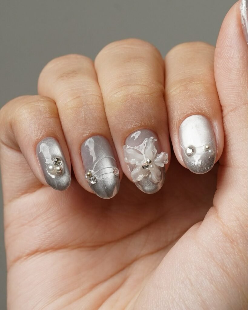 Artistic grey nails ideas incorporating 3D floral designs, pearls, and crystals for a delicate, luxurious manicure.