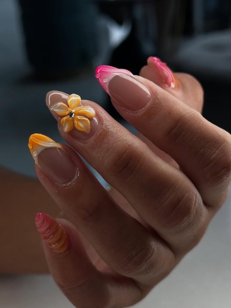 Inspiring hawaii nails ideas showcasing vibrant sunset gradients in pink, orange, and yellow with a delicate 3D flower accent on pointed manicure.