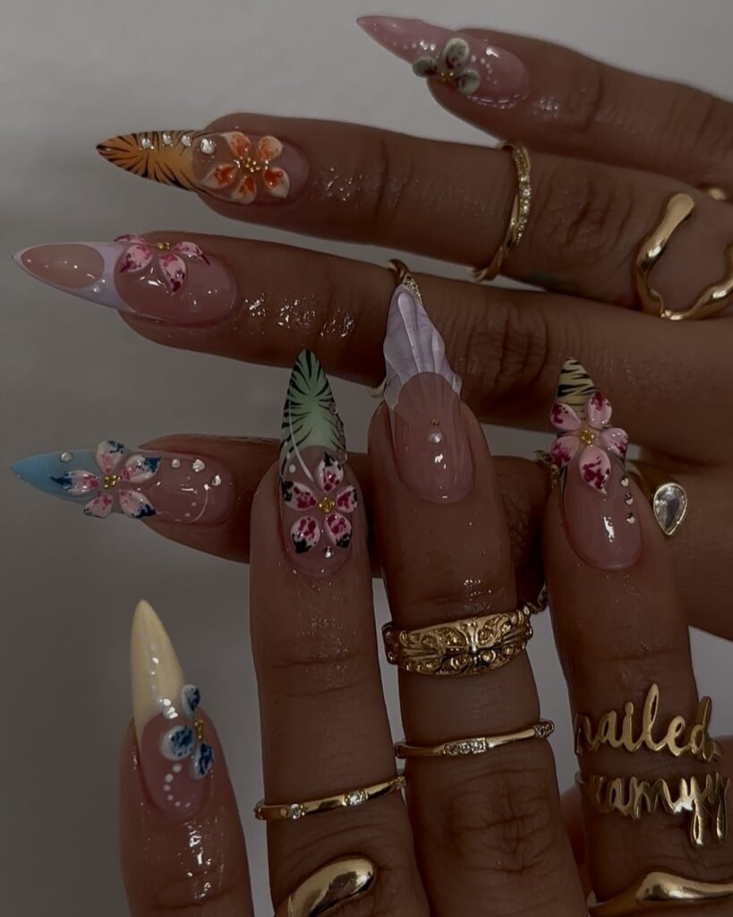 Exotic hawaii nails ideas with stiletto shapes, vibrant floral blooms, leaf patterns, and tiger stripes for an adventurous paradise theme.