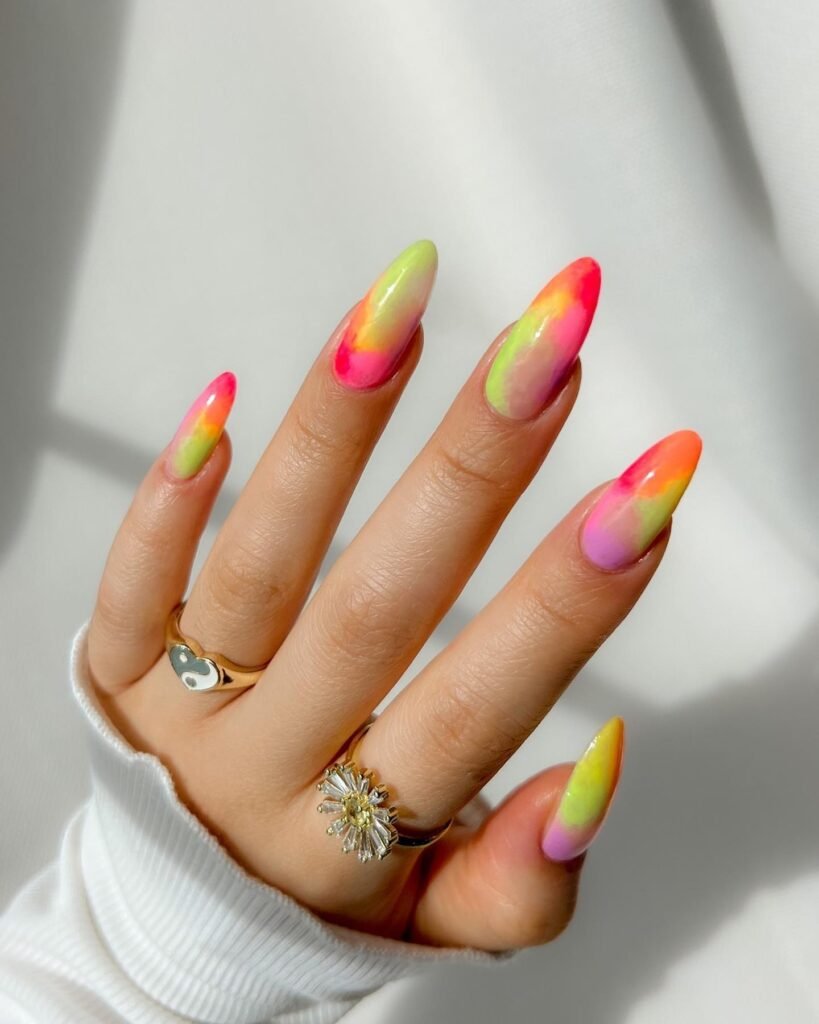 Colorful rainbow ombre May nails ideas featuring vibrant gradients on almond-shaped manicure with stylish rings.
